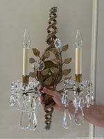 Single sconce held by hand showing front view and scale