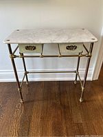 Front view of entire console table showing marble top, brass frame, drawers and feet