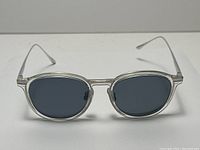 Front view showing clear acetate frame and dark tinted lenses