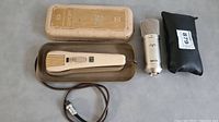 Grundig 515 microphone in metal case alongside Apex 435 microphone and black zippered pouch