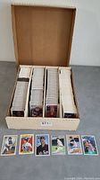 Box of over 2500 baseball cards arranged in dividers showing many cards stacked upright and some cards displayed in front of the box.