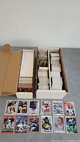 Two boxes filled with football trading cards, cards stacked neatly inside showing thickness of the lot.