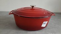 Side view of Le CUISOTOT cast iron long pot, red enamel exterior with lid on, showing pot shape and handles.