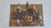 Front view of the vintage metal wall sculpture showing the architectural relief elements and patinated finish.