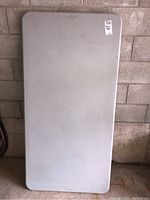 Top view of the rectangular folding table showing surface condition and peelable sticker.