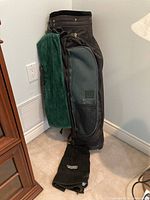 Wilson Leviator black and green golf bag standing upright showing fabric and attached green towel