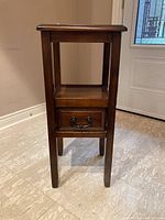 Front view of wooden hall table showing drawer and open shelf, dark brown finish.