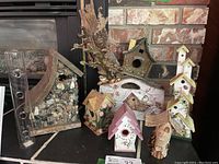 Group image of all birdhouses and glass feeder showing diverse styles and materials.