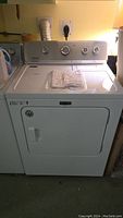 Full front view of white Maytag dryer installed next to washer, showing overall condition and styling.