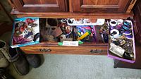 Wide shot of open drawer containing three boxes filled with assorted vintage costume jewelry pieces including bracelets, rings, and pins.