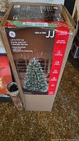 Boxed GE 5 ft Pre-lit Just Cut Colorado Spruce tree packaging with product details on branding, height, and safety instructions.