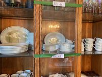 Wide view of china pieces arranged in display cabinet