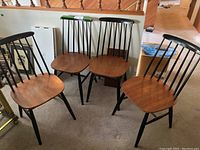 Four chairs arranged together in a carpeted room under a railing