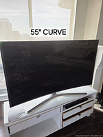 Front view of the curved screen TV on cabinet