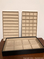 Front view of the set showing the three smaller compartment trays standing upright behind the larger rectangular vault tray in front.