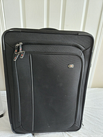 Front view of black Victorinox carry-on luggage showing two zippered compartments and branded logo plate.