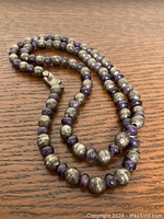 Full view of coiled necklace on wood surface