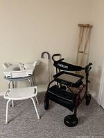 Photo showing home medical accessibility equipment including Nexus rollator walker, shower chair, commode seat, cane, and crutches.