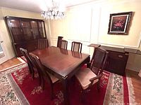 Overview of dining table, chairs, china cabinet hutch, and bar sideboard in dining room