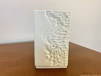 Front view of the white bisque porcelain vase with abstract embossed optic art pattern and geometric linear texture.