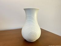 Full view of the white bisque porcelain vase showing its raised dot op art design and form.