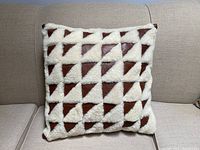 Front view of Mid Century Modern style pillow showing geometric triangle pattern alternating brown and white textured materials.