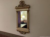 Front and angled views of the vintage Syroco ornate gold wall mirror showing detailed Baroque and Rococo style carvings on the frame.