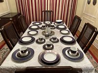 Full table view showing eight place settings: dinner plates, salad plates, soup bowls, cups and saucers
