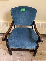 Front view of the blue crushed velvet upholstered wooden arm chair showing fabric texture and wooden armrests.