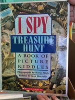 Cover of 'I SPY Treasure Hunt: A Book of Picture Riddles' with photographic cover showing various treasure items and title text.