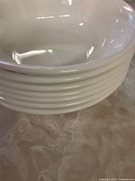 Stack of white Corelle soup/cereal bowls showing smooth interior surface and rounded edges.