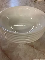 Stack of six white bowls showing inside and outside profile