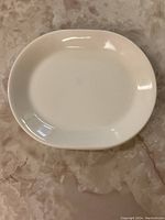 White oval platter on marble surface without measuring tape