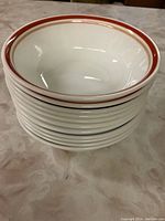 Stack of Corelle bowls with rust colored double rim stripes