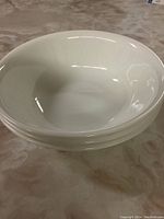 Stack of three smaller white bowls showing rounded shape and clean white finish.