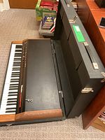 Rhodes electric piano inside open hard case showing keyboard and control panel from side