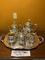 Full view of silverplate tea service including coffee pot, teapot, creamer, sugar bowl on large tray