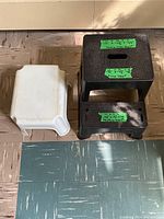 Top view of black two-step stool and white one-step stool placed side by side on tiled floor showing their size and structure