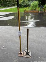 Both tampers standing on asphalt, showing size difference and handles