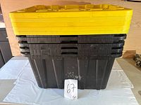 Stacked view of the five black storage totes with yellow lids showing external condition.