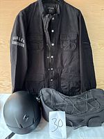 Full display of Harley-Davidson black spring jacket laid flat with front view, showing logo on sleeve