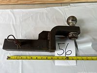 Heavy duty hitch tongue showing entire length with 2 5/16 inch ball and locking pin, placed beside measuring tape indicating approximately 12.5 inch length.