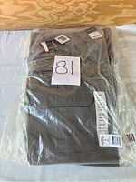 Photo of five pairs of new, grey women's tactical pants sealed in plastic packaging with size and product tags visible.