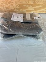 Photo of the 5 packaged grey tactical pants stacked together with visible size label 8.