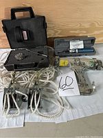 Four tools displayed: pneumatic caulking tool, torque screwdriver, compound pulley with rope, magnetic holder in plastic case.