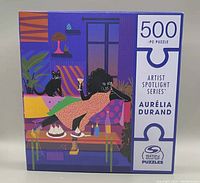Front view of the box for the 500-piece Artist Spotlight Series puzzle "Lemon Cake" by Aurélia Durand, showing the colorful artwork and branding.