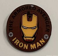 Front view of Iron Man collector pin showing helmet and text The Armored Avenger and Iron Man.