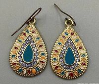 Close-up image of the pair of vintage boho gold toned teardrop shaped dangle earrings with multicolor enamel accents and clear rhinestones.
