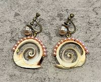 Front view of the earrings showing swirl natural shell design, pink pearl tone beads, and larger pearl tone bead with screw back clasps