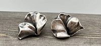 Front view of the pair of vintage silver color screw back earrings showing their stylized petal shapes and form.